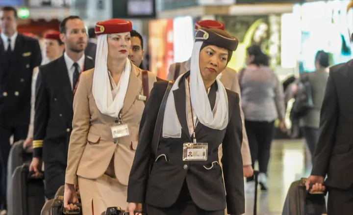 Hostess e passeggeri in transito all’aeroporto internazionale di Malpensa