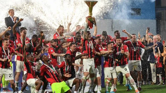 AC Milan's Italian defender Alessio Romagnoli (C) and AC Milan's players celebrate with the winner's trophy after AC Milan won the Italian Serie A football match between Sassuolo and AC Milan, securing the "Scudetto" championship on May 22, 2022 at the Mapei - Citta del Tricolore stadium in Sassuolo. (Photo by Tiziana FABI / AFP)