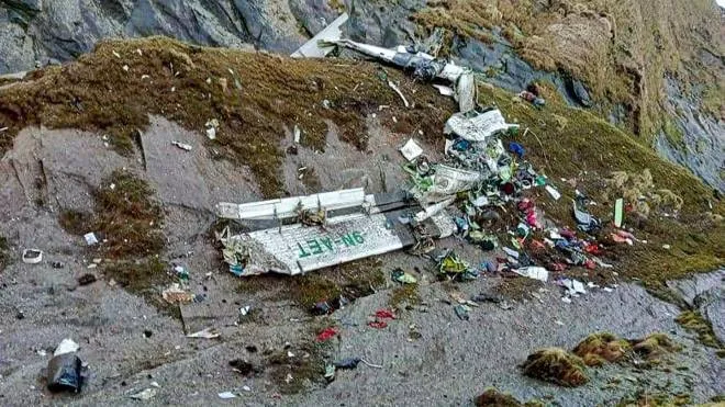 EDITORS NOTE: Graphic content / TOPSHOT - The wreckage of a Twin Otter aircraft, operated by Nepali carrier Tara Air, lay on a mountainside in Mustang on May 30, 2022, a day after it crashed. - Nepali rescuers pulled 14 bodies on May 30 from the mangled wreckage of a passenger plane strewn across a mountainside that went missing in the Himalayas with 22 people on board. (Photo by Bishal MAGAR / AFP)