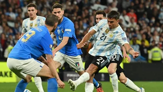Argentina's striker Paulo Dybala (R) shoots to score their third goal during the 'Finalissima' International friendly football match between Italy and Argentina at Wembley Stadium in London on June 1, 2022. - The Azzurri face the South American continental champions in the inaugural Finalissima at Wembley. (Photo by Glyn KIRK / AFP)