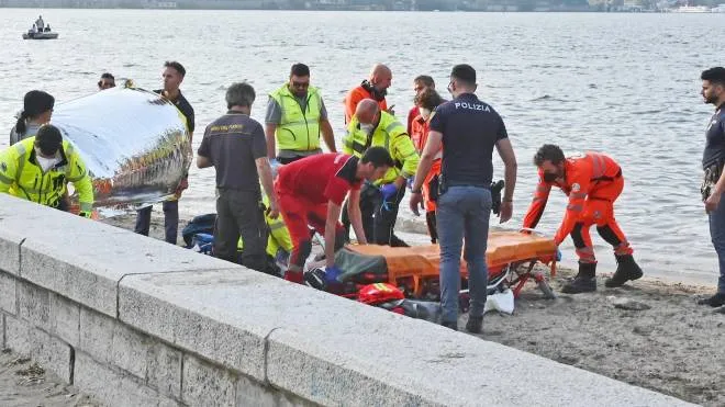 I soccorritori sulla riva dopo aver recuperato il ragazzo dal lago