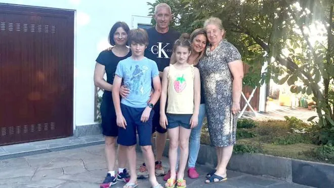 Da sinistra, Alona, Roman e Mariia e la nonna Zhanna. Dietro la famiglia che li ospita, Marco La Rosa e Alessandra Nonnis