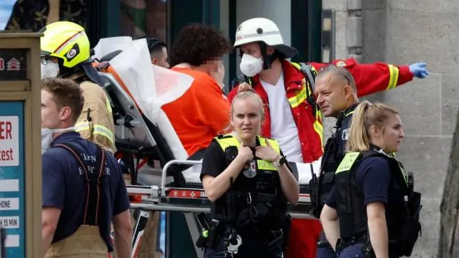 Rescue workers tend to an injured person on a stretcher at the site where a car ploughed into a crowd near Tauentzienstrasse in central Berlin, on June 8, 2022. - One person was killed and eight injured when a car drove into a group of people in central Berlin on June 8, the fire service said. A police spokeswoman said the driver was detained at the scene after the car ploughed into a shop front along busy shopping street Tauentzienstrasse. It was not clear whether the crash was intentional. (Photo by Odd ANDERSEN / AFP)