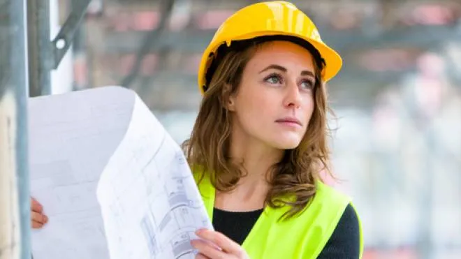 Young and cute female engineer with office blueprints. Outdoors