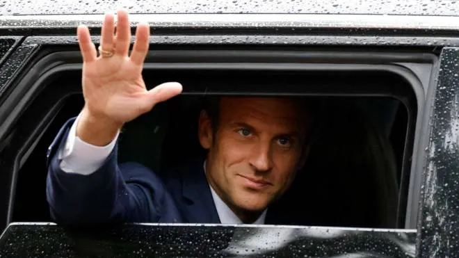 France's President Emmanuel Macron waves as he leaves after casting his vote in the second stage of French parliamentary elections at a polling station in Le Touquet, northern France on June 19, 2022. (Photo by Ludovic MARIN / AFP)