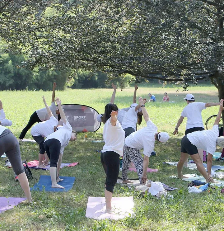 A lezione di yoga sul prato con istruttori qualificati