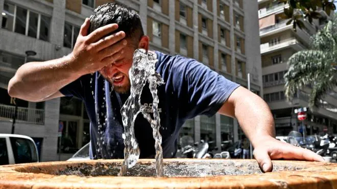 Un uomo si bagna la testa ad una fontanella al centro di Napoli per trovare combattere la morsa di caldo di Caronte, 04 luglio 2022. ANSA/CIRO FUSCO