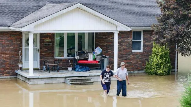 A couple abandons their home flooded by the waters of the North Fork of the Kentucky River in Jackson, Kentucky on July 28, 2022. - At least three people have died after torrential rains caused massive flooding in eastern Kentucky, leaving a number of people stranded on rooftops and in trees, the governor of the southeastern US state said Thursday. (Photo by LEANDRO LOZADA / AFP)