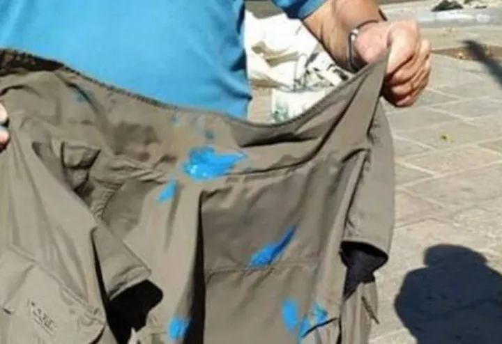 Uno dei militanti di Italia Viva mostra il suo giubbotto imbrattato di vernice blu