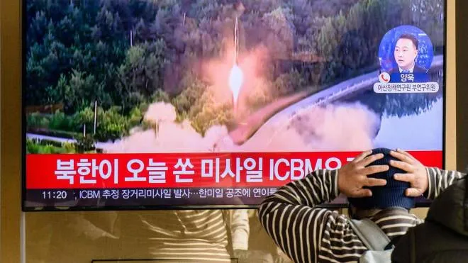 A man watches a television showing a news broadcast with file footage of a North Korean missile test, at a railway station in Seoul on November 18, 2022. - A suspected intercontinental ballistic missile launched by North Korea on Friday is believed to have fallen in Japan's exclusive economic waters, Japanese Prime Minister Fumio Kishida said. (Photo by Anthony WALLACE / AFP)