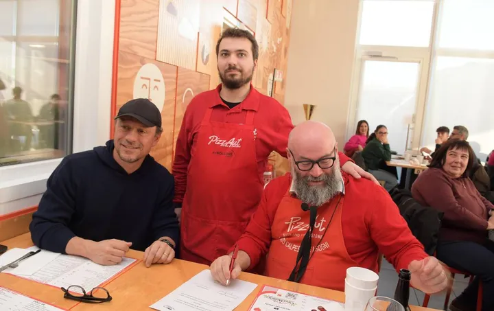 Stefano Accorsi in visita da PizzAut la pizzeria dove lavorano ragazzi autistici insieme al fondatore Nico Acampora e a Lorenzo Ziliani durante la firma del contratto a tempo indeterminato