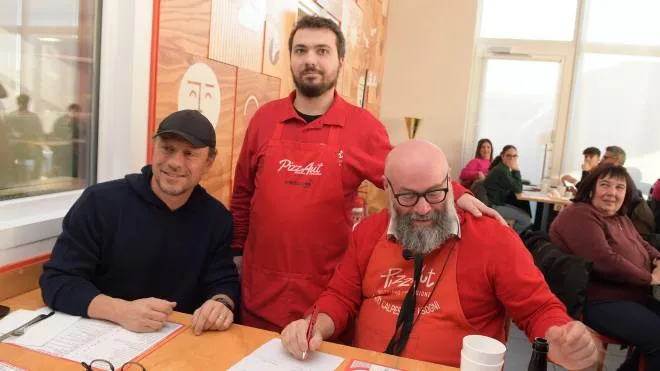 Stefano Accorsi in visita da PizzAut la pizzeria dove lavorano ragazzi autistici insieme al fondatore Nico Acampora e a Lorenzo Ziliani durante la firma del contratto a tempo indeterminato