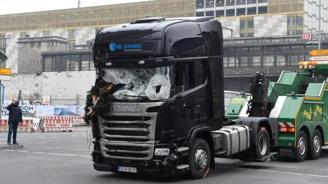 epa05683436 The damaged cab of a truck used in an attack on a Christmas market in Berlin is towed away from the scene at Breitscheidplatz, Berlin, Germany, 20 December 2016. At least 12 people were killed and dozens injured when a truck drove into the Christmas market on 19 December, in what authorities believe was a deliberate attack.  EPA/RAINER JENSEN