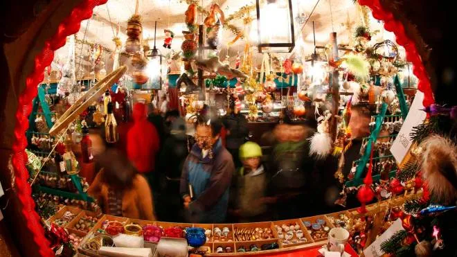 People look at Christmas decorations on a stall at the opening day of Germany's oldest Christkindlesmarkt (Christ Child Market) in Nuremberg November 28, 2014. The first official record of this pre-Christmas market dates back to 1628. A list of notices for stall holders from 1737 shows that almost all of Nuremberg's craftsmen were represented. Every year, Germany's traditional markets, such as the centuries-old Christkindlesmarkt in medieval Nuremberg, draw millions of visitors, both local and foreign. They open before the first Sunday of Advent and usually continue until December 24 at 12 noon.  REUTERS/Michaela Rehle (GERMANY - Tags: SOCIETY BUSINESS TRAVEL)