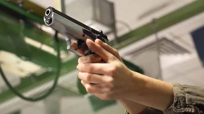 Lucidi Woman takes lessons in shooting with a handgun on the shooting range iStockphoto