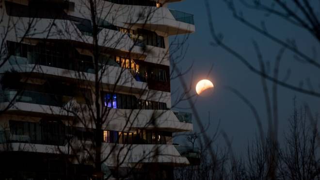 Milano, l'eclissi di luna vista da Citylife (foto Lapresse)