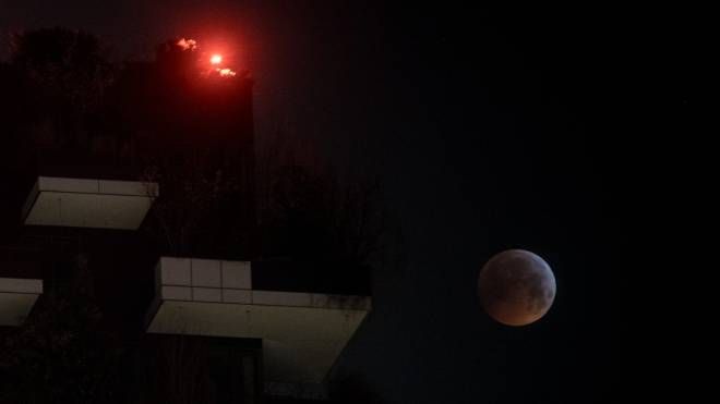 Milano, l'eclissi di luna vista dal Bosco Verticale (foto Lapresse)