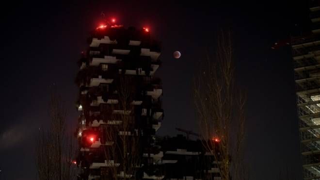 Milano, l'eclissi di luna vista dal Bosco Verticale (foto Lapresse)