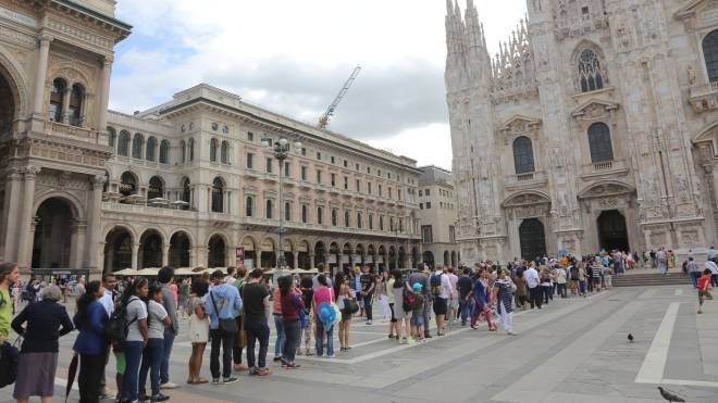 Turisti in piazza Duomo a Milano (Newpress)