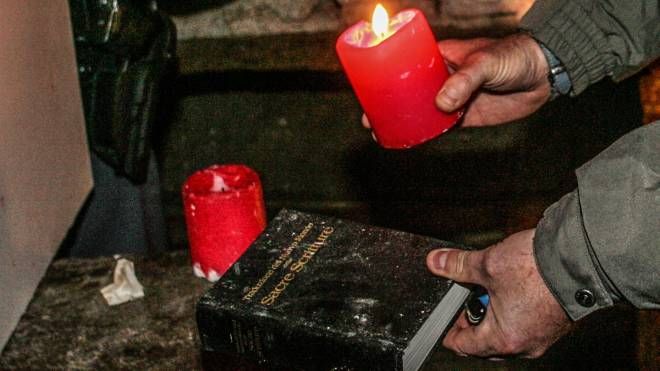 Una bibbia e delle candele utilizzate per un rito esoterico