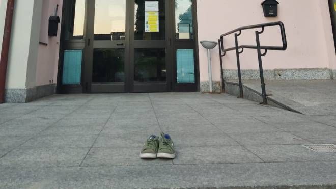 Le scarpe del bimbo lasciate davanti al municipio in segno di protesta