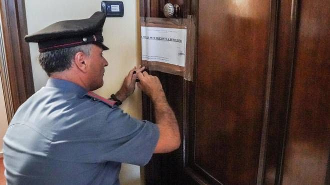 I carabinieri mettono i sigilli sulla porta dell'appartamento della coppia