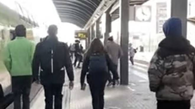I passeggeri scendono dal treno: sulla banchina è in corso la rissa